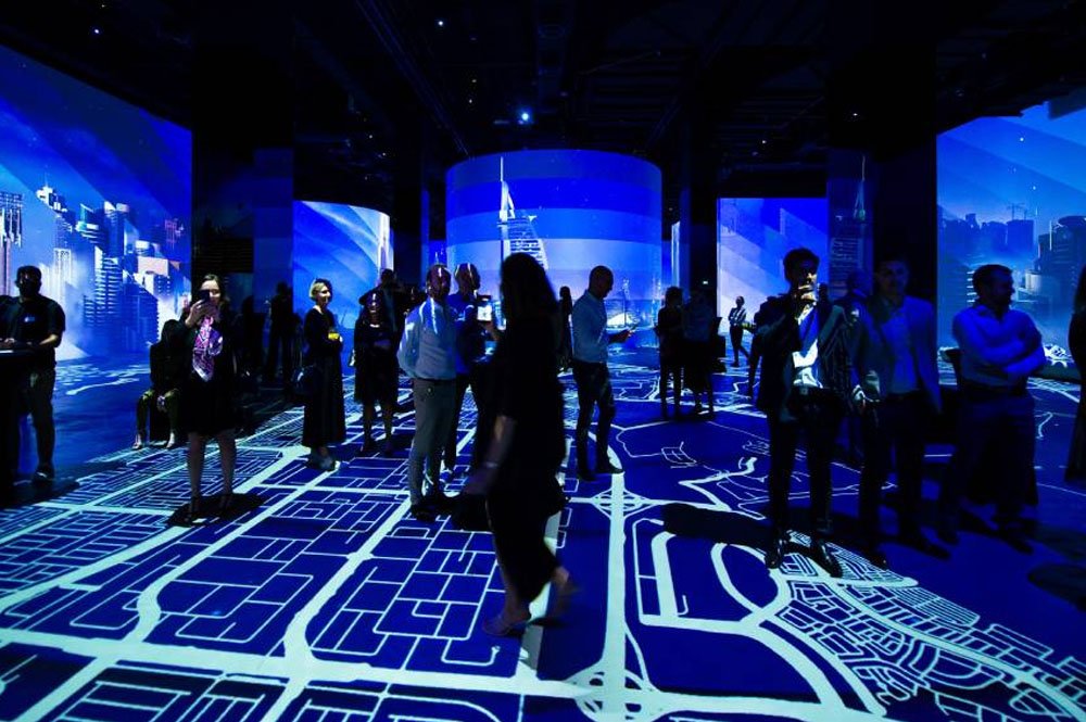 Visitors admiring artwork inside Infinity des Lumeires