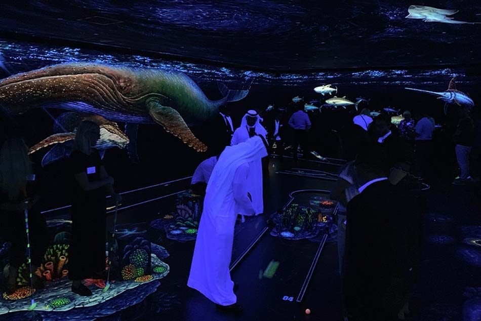 Players enjoying golf session with tickets to Dubai's 3D Blacklight Minigolf